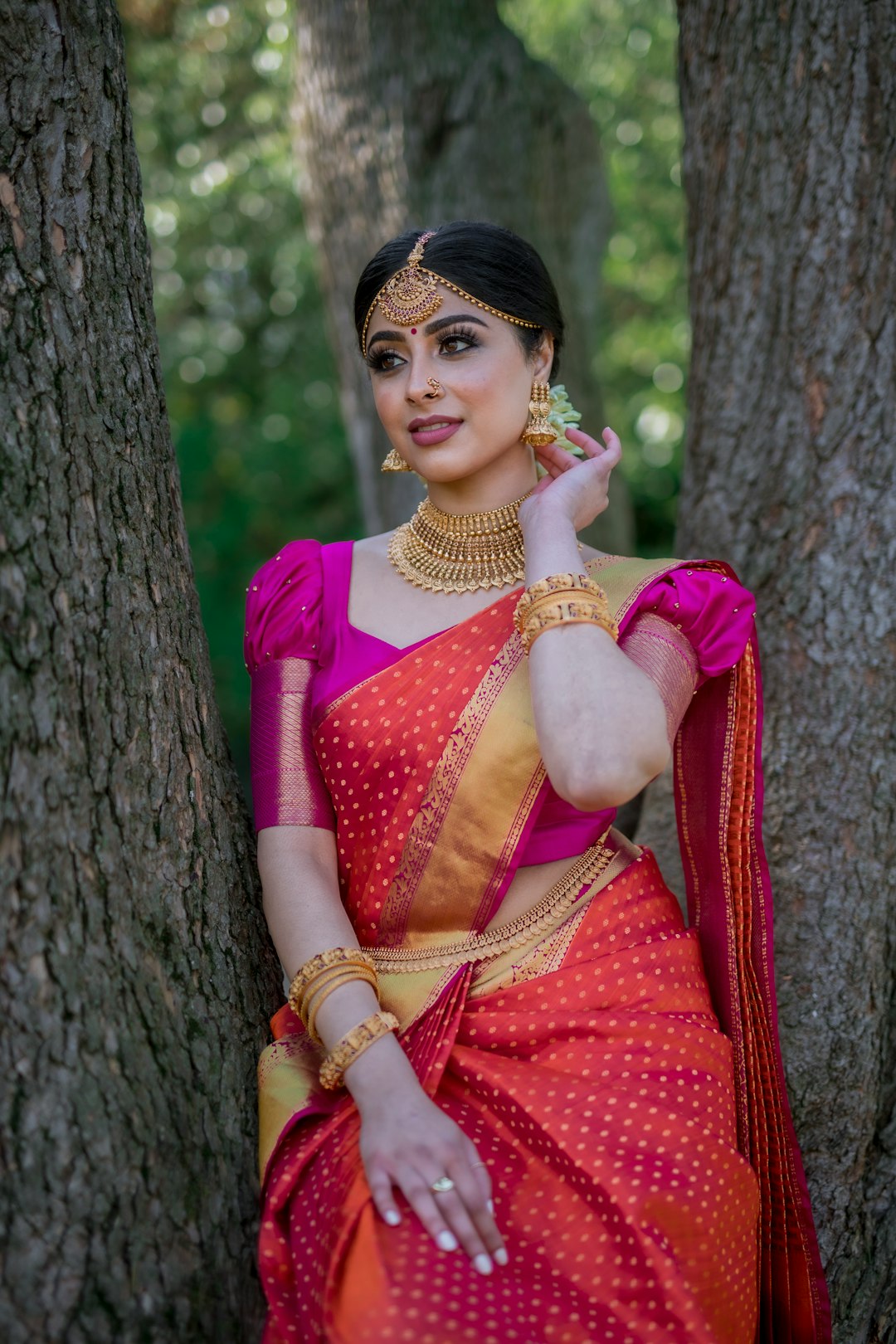 Woman in festive pink and gold silk saree with traditional jewellery