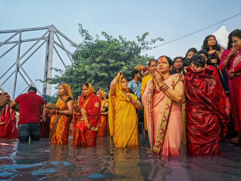 A group of people standing in a flooded area during Chhath Puja